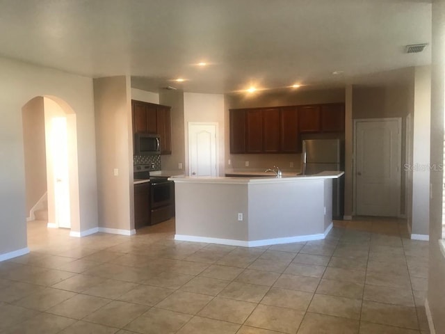 3102 Westbrook Rd, Kissimmee, FL 34746 - kitchen featuring light tile patterned floors, stainless steel appliances, visible vents, arched walkways, and light countertops