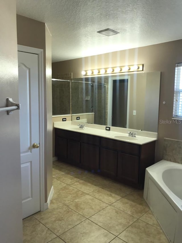 3102 Westbrook Rd, Kissimmee, FL 34746 - full bath with a garden tub, a textured ceiling, a shower stall, and a sink