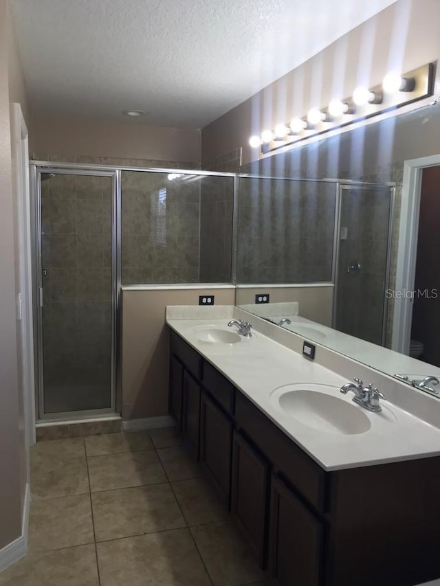 3102 Westbrook Rd, Kissimmee, FL 34746 - bathroom with a textured ceiling, tile patterned floors, a sink, and a shower stall