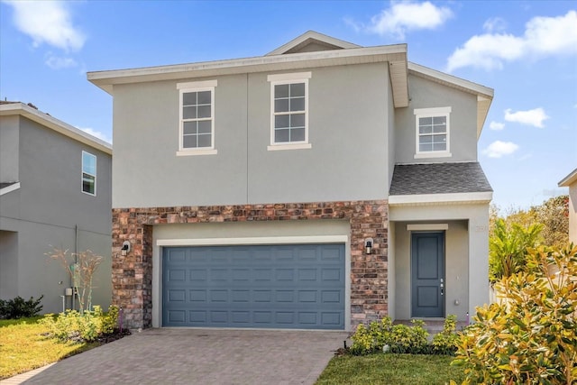 traditional home with stone siding, stucco siding, an attached garage, and driveway