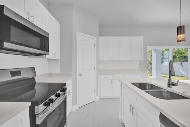 kitchen featuring a sink, stainless steel appliances, white cabinetry, light countertops, and marble finish floor