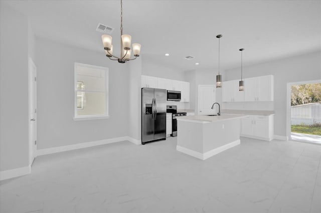 kitchen with a kitchen island with sink, appliances with stainless steel finishes, baseboards, and a sink