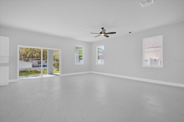 spare room featuring baseboards, visible vents, and plenty of natural light