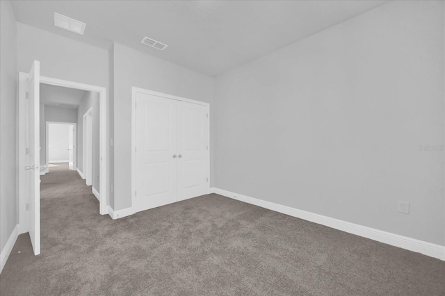 unfurnished bedroom featuring baseboards, a closet, visible vents, and carpet