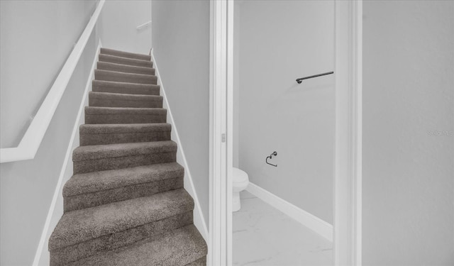 stairs featuring marble finish floor and baseboards