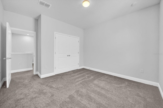 unfurnished bedroom featuring carpet flooring, visible vents, and baseboards