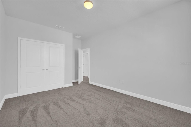 unfurnished bedroom with baseboards, a closet, visible vents, and carpet