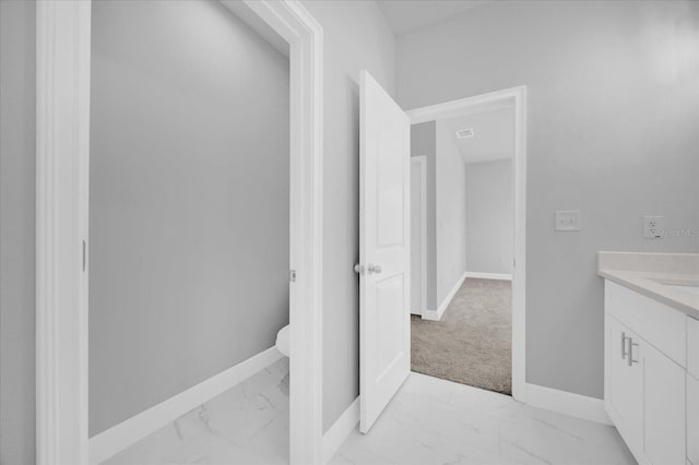 bathroom with vanity, marble finish floor, and baseboards