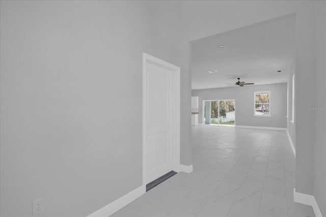 hallway featuring baseboards and marble finish floor