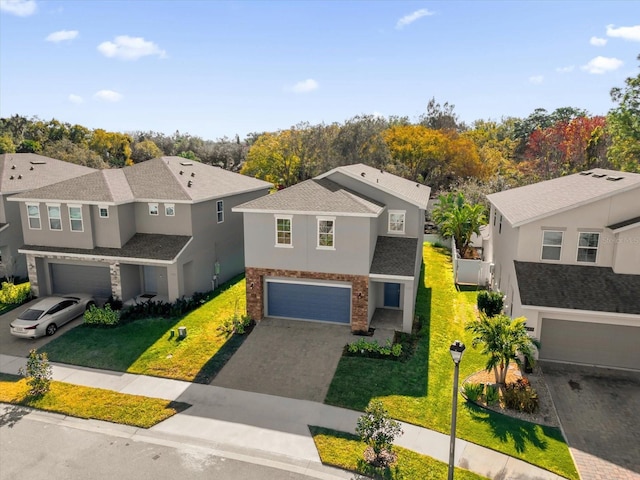 view of front of house featuring stucco siding, a residential view, an attached garage, and decorative driveway