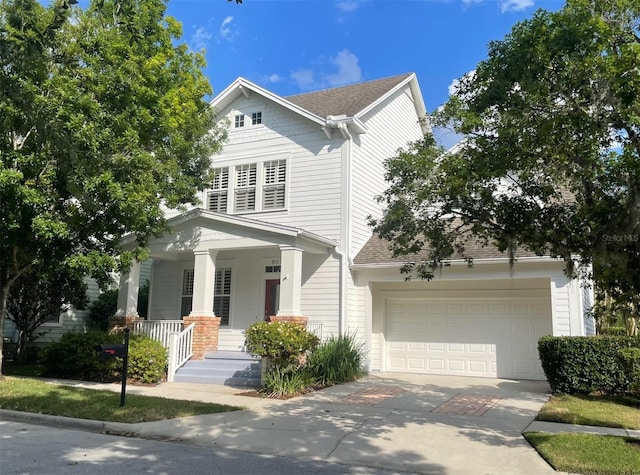 907 Pawstand Rd, Celebration, FL 34747 - view of front of house with concrete driveway, covered porch, a shingled roof, and an attached garage