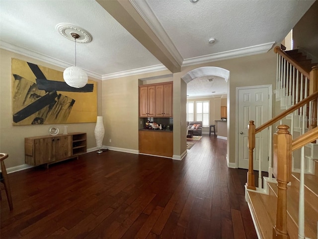 907 Pawstand Rd, Celebration, FL 34747 - living area featuring ornamental molding, dark wood-style floors, arched walkways, a textured ceiling, and stairway