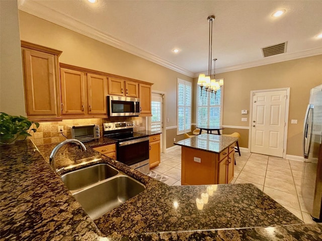 907 Pawstand Rd, Celebration, FL 34747 - kitchen featuring stainless steel appliances, a sink, decorative backsplash, a kitchen island, and brown cabinetry
