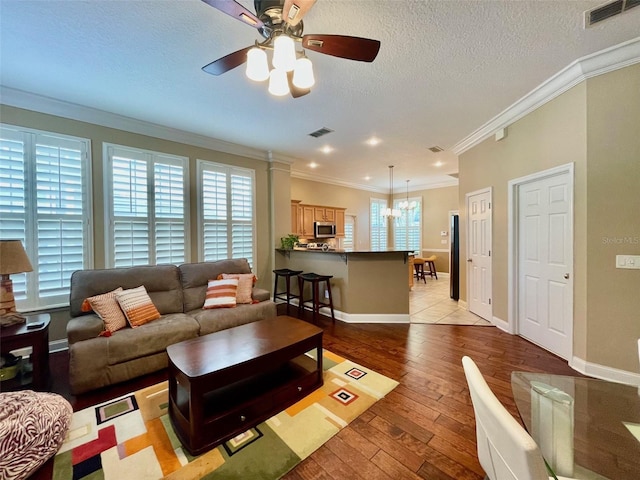 907 Pawstand Rd, Celebration, FL 34747 - living area featuring ceiling fan, light wood finished floors, ornamental molding, baseboards, and a textured ceiling