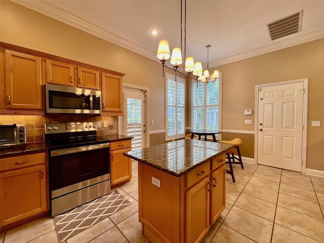 907 Pawstand Rd, Celebration, FL 34747 - kitchen featuring stainless steel appliances, a chandelier, ornamental molding, tasteful backsplash, and a kitchen island