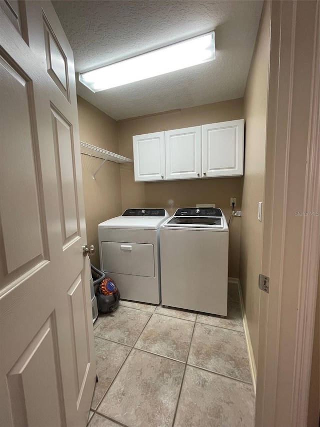 907 Pawstand Rd, Celebration, FL 34747 - laundry room featuring cabinet space, washer and clothes dryer, light tile patterned floors, a textured ceiling, and baseboards