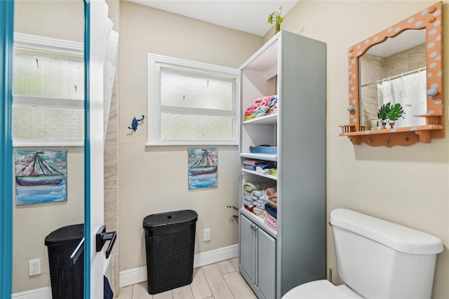 bathroom with toilet, baseboards, and vanity