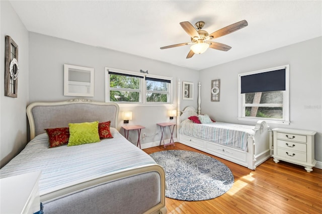 bedroom with baseboards, ceiling fan, and wood finished floors
