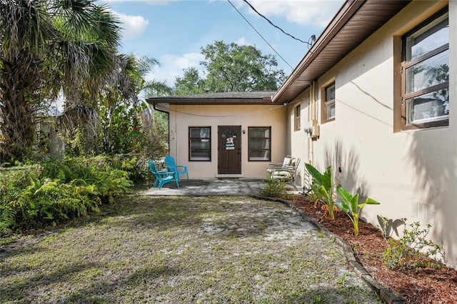 property entrance featuring stucco siding and a patio area