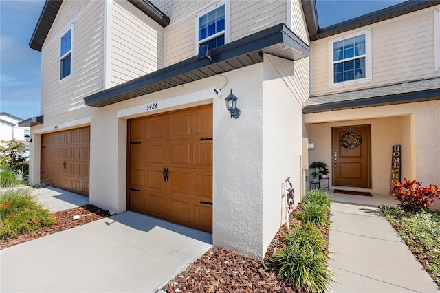 5424 Companion Ln, Tampa, FL 33619 - property entrance featuring an attached garage, stucco siding, and driveway