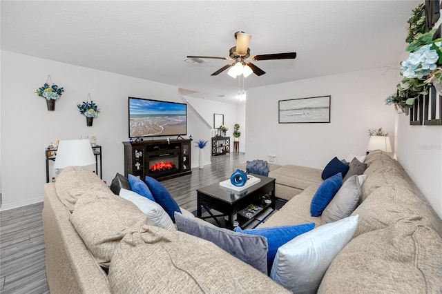 5424 Companion Ln, Tampa, FL 33619 - living area featuring wood finished floors, a ceiling fan, a glass covered fireplace, and baseboards