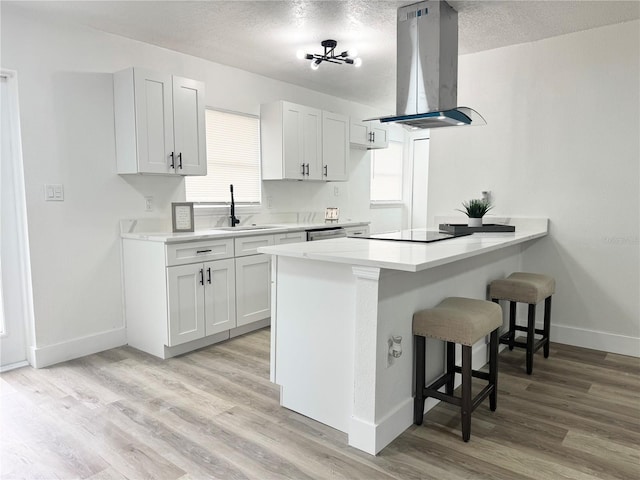 1098 Leeway Ct, Orlando, FL 32810 - kitchen featuring baseboards, a sink, island range hood, and a breakfast bar area