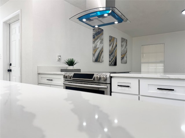 1098 Leeway Ct, Orlando, FL 32810 - kitchen featuring electric range, light countertops, white cabinetry, and island exhaust hood