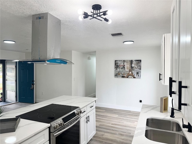1098 Leeway Ct, Orlando, FL 32810 - kitchen featuring stainless steel range with electric cooktop, light stone counters, island range hood, and a textured ceiling