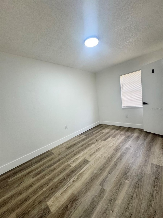 1098 Leeway Ct, Orlando, FL 32810 - unfurnished room with a textured ceiling, dark wood-type flooring, and baseboards