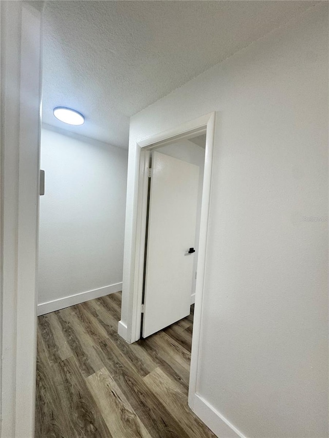 1098 Leeway Ct, Orlando, FL 32810 - hall with a textured ceiling, wood finished floors, and baseboards