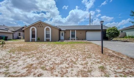 ranch-style house featuring concrete driveway, stucco siding, and an attached garage