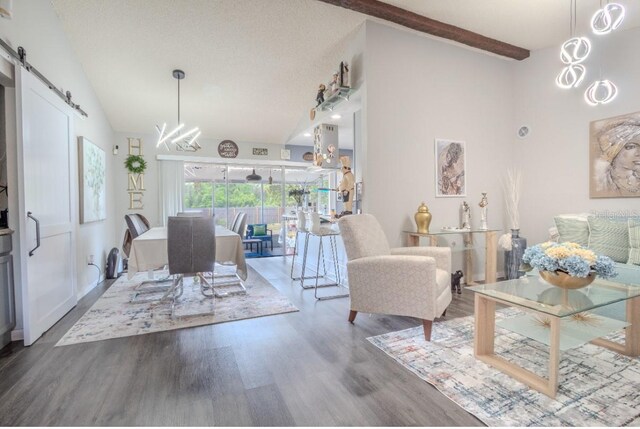 living room featuring high vaulted ceiling, beamed ceiling, a barn door, and wood finished floors