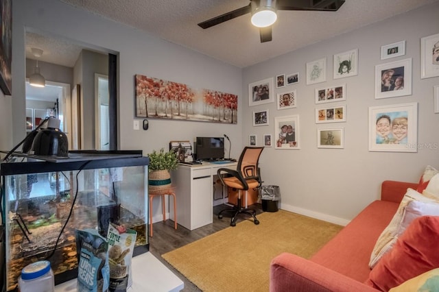 office featuring a textured ceiling, baseboards, and a ceiling fan