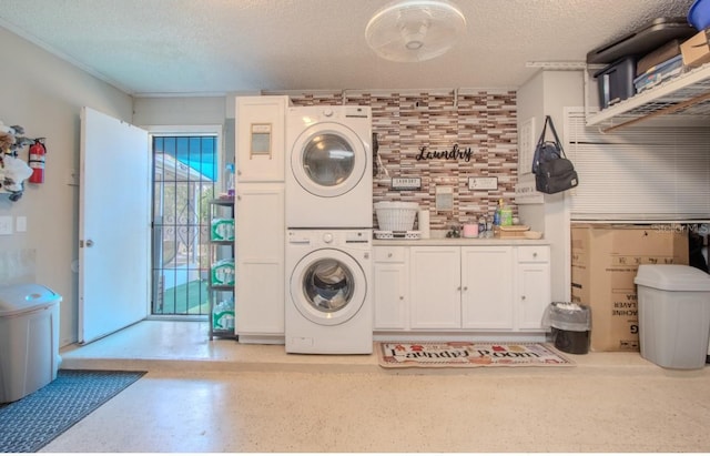 washroom with laundry area, stacked washer / dryer, and a textured ceiling