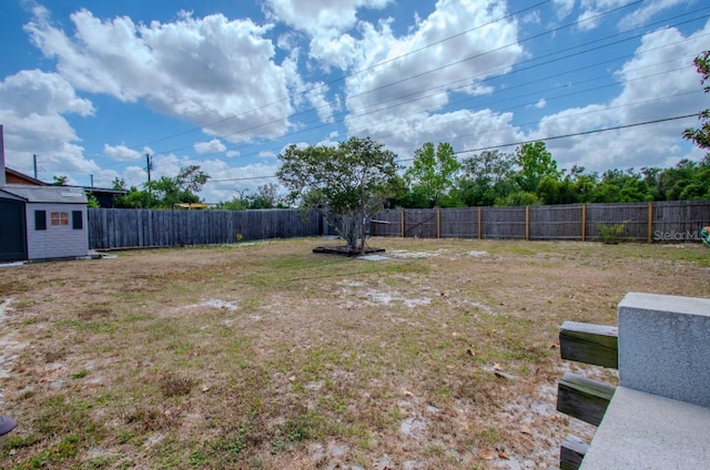 view of yard featuring an outdoor structure, a storage shed, and a fenced backyard