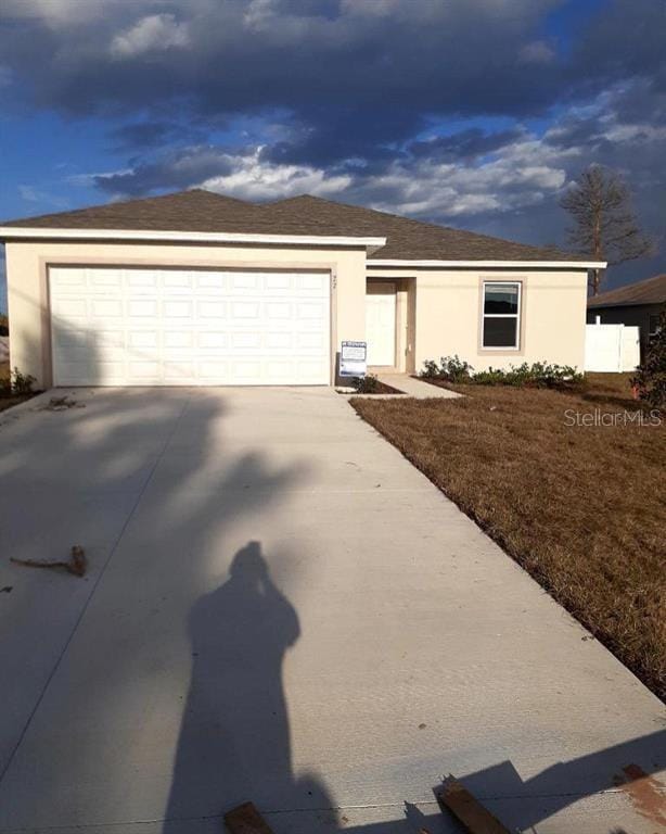 view of front of house with driveway, stucco siding, and an attached garage