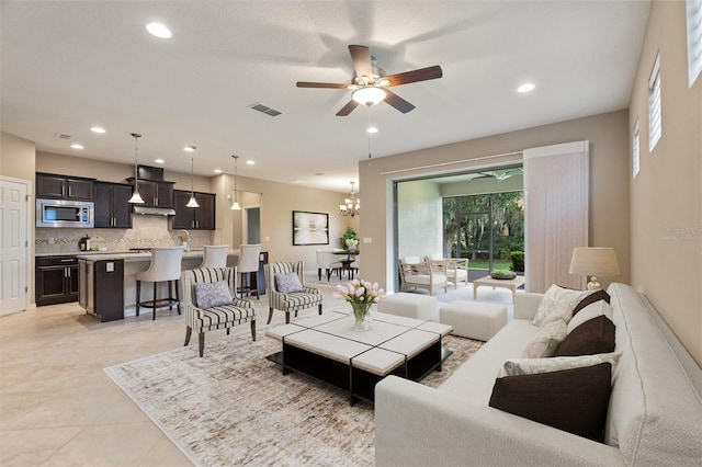living area with a ceiling fan, recessed lighting, a chandelier, and light tile patterned floors