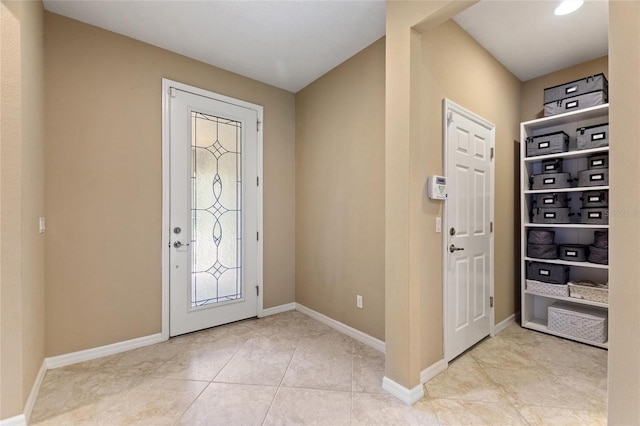 foyer featuring baseboards and light tile patterned floors