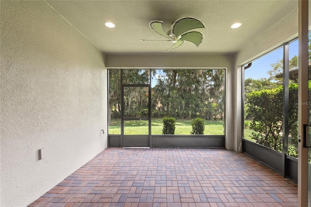 unfurnished sunroom featuring ceiling fan