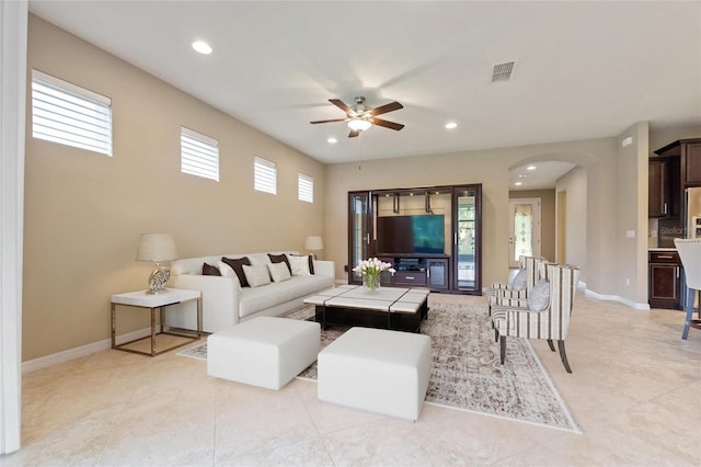 living area with ceiling fan, arched walkways, recessed lighting, baseboards, and light tile patterned floors