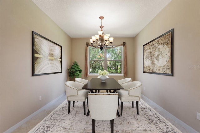 dining space featuring a chandelier and baseboards