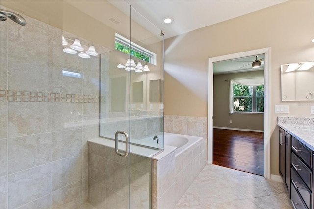 full bath featuring a stall shower, vanity, and a bath