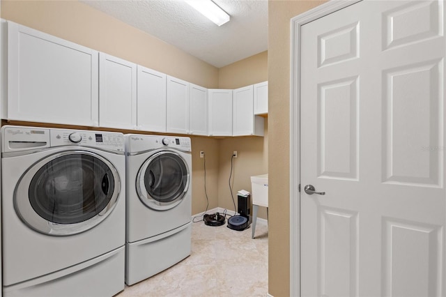 laundry room with cabinet space, separate washer and dryer, a textured ceiling, and baseboards