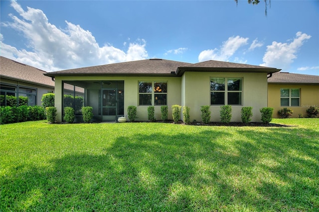 view of front of property with a front yard, stucco siding, and a sunroom