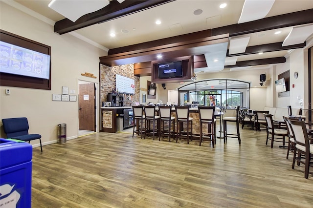 bar area with wood finished floors, baseboards, beamed ceiling, recessed lighting, and crown molding