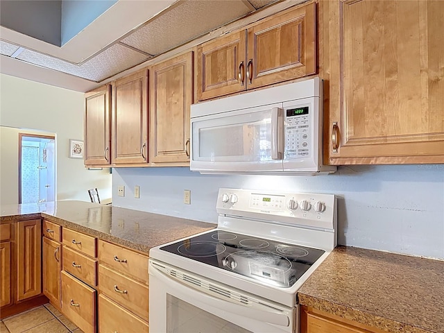 3110 Short Leaf Pine Ct, Kissimmee, FL 34746 - kitchen featuring white appliances, brown cabinets, a peninsula, and light tile patterned floors