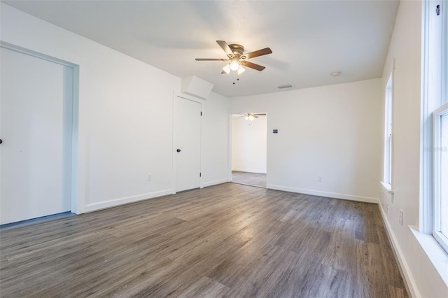 1007 11th St, Saint Cloud, FL 34769 - unfurnished bedroom with wood finished floors, visible vents, two closets, a ceiling fan, and baseboards