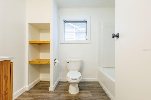 1007 11th St, Saint Cloud, FL 34769 - bathroom with vanity, toilet, wood finished floors, and baseboards