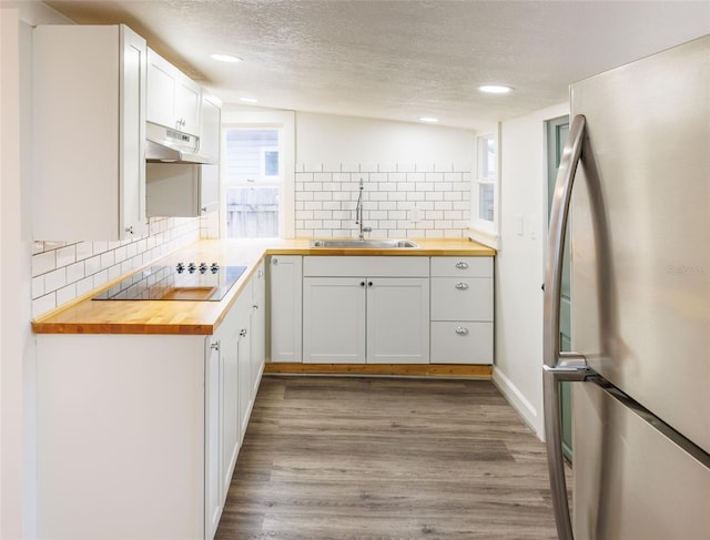 1007 11th St, Saint Cloud, FL 34769 - kitchen featuring freestanding refrigerator, butcher block counters, a sink, black electric cooktop, and a textured ceiling