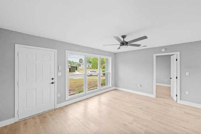 4445 Stuart Ave, Titusville, FL 32780 - unfurnished living room featuring ceiling fan, baseboards, and light wood-type flooring